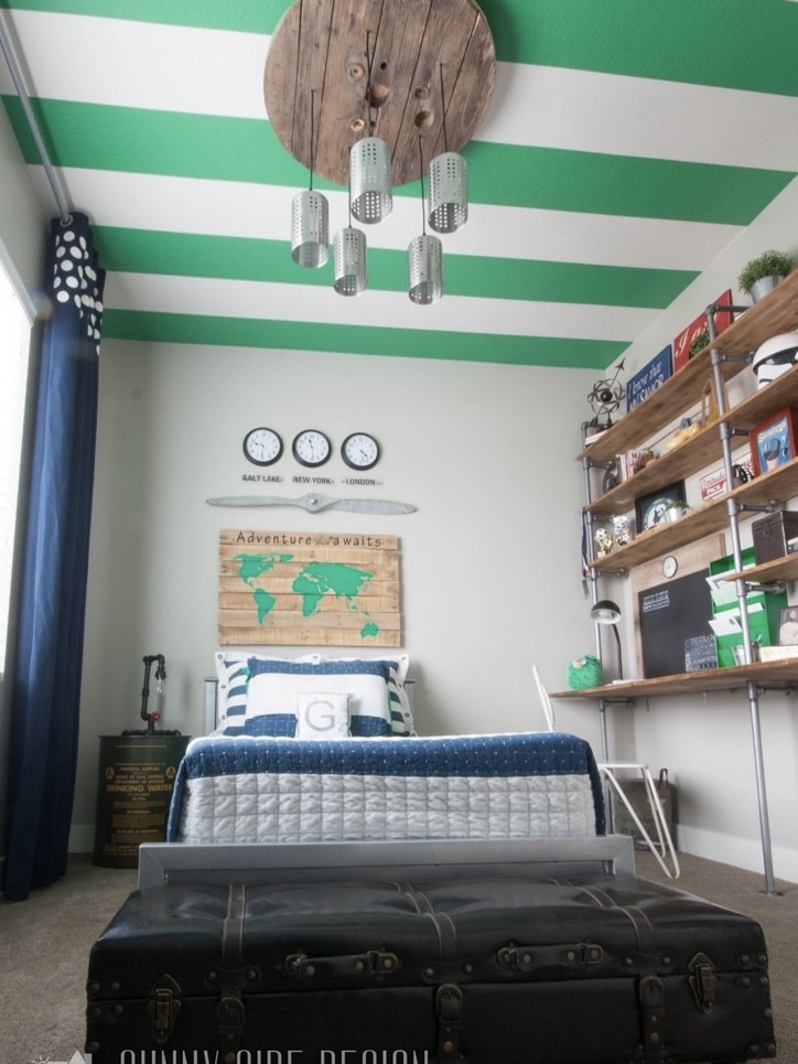 Teen bedroom with striped ceiling, built in desk, industrial lighting and airplane propellor.