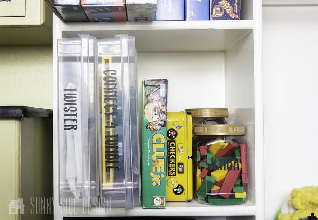 Organize toys with clear labeled plasitc containers on shelves in a closet.
