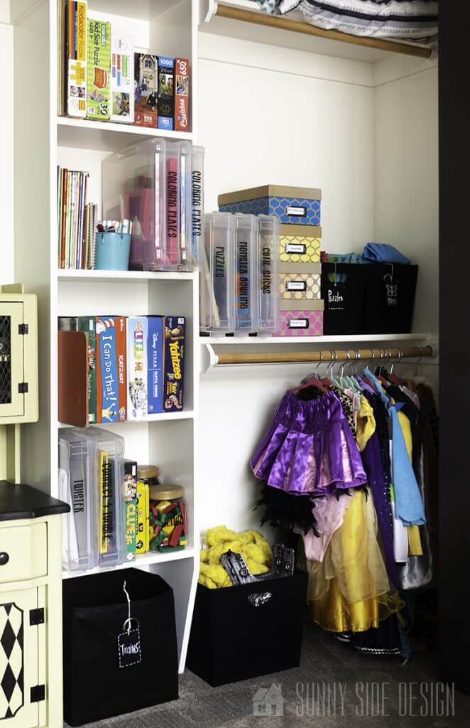 Closet in playroom, organize toys and dress up clothes hanging on clothing rod.
