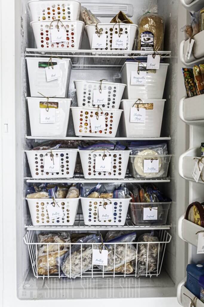 The best Freezer organization in white plastic storage bins and labels for easy finding.