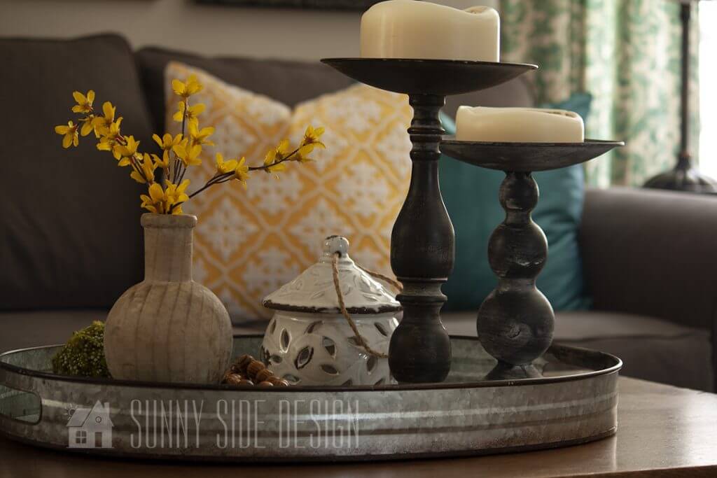 Spring Decorating ideas for the coffee table, forsythia in a natural wood vase, birdhouse and white candles.