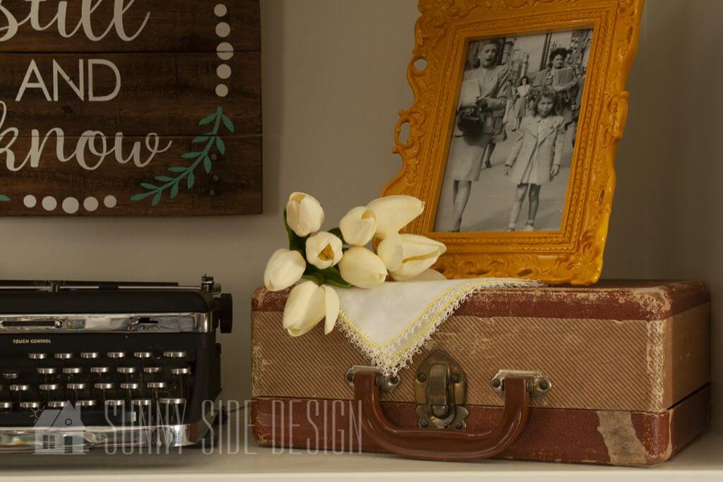 Shelf styled for spring with cream colored tulips.