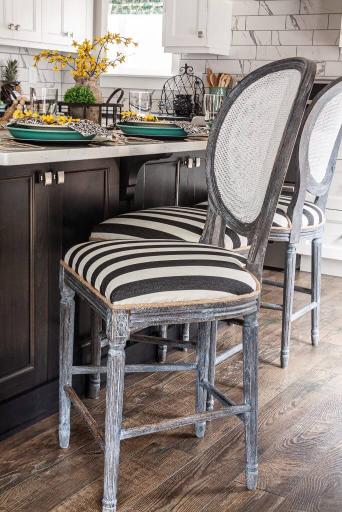 Kitchen bar styled with spring table setting with black and white striped chairs.