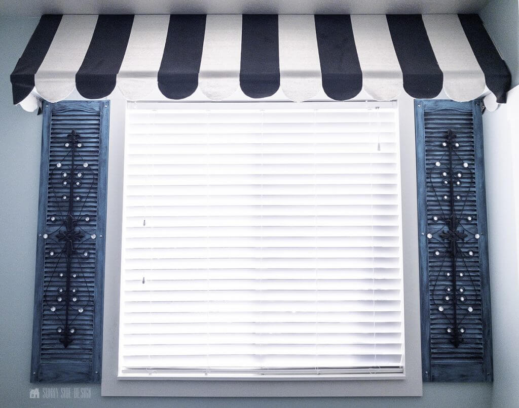 WINDOW TREATMENT IDEAS, black and white striped awning over window, flanked by teal and iron shutters.