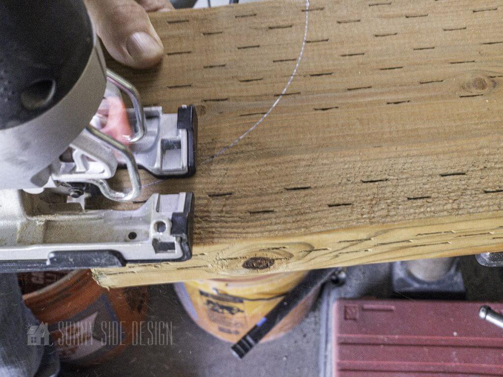 A jigsaw is used to cut the arc in the wood.