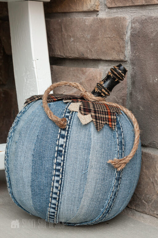 DIY denim pumpkin decor with brown plaid fabric, large pinecone and fall pillow.