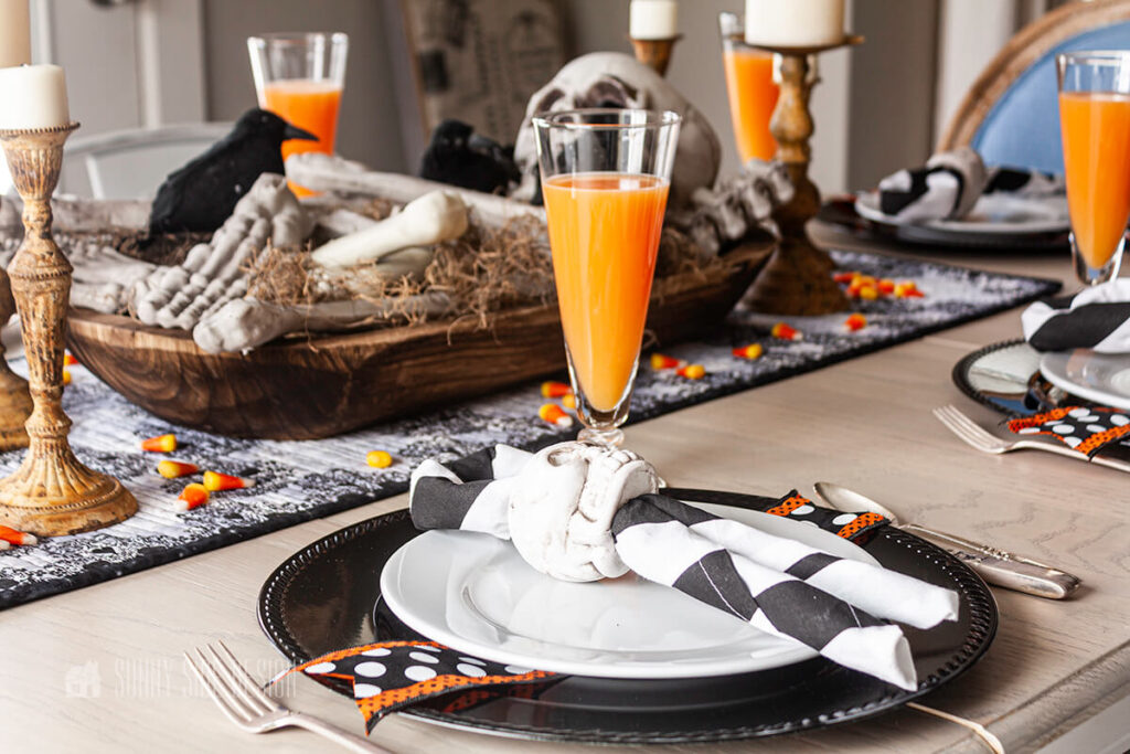 Halloween party Ideas: Set a spooky table for Halloween party guest with skull napkin rings and a skeleton centerpiece.