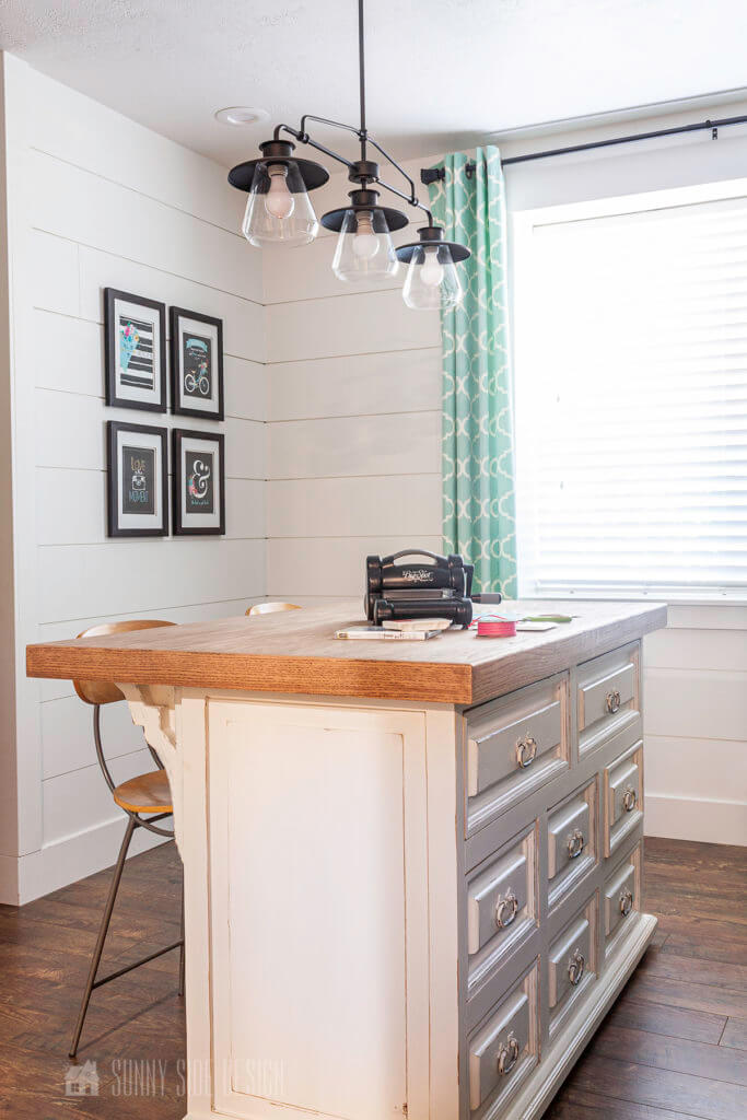 Home Office Ideas, a standing workstation was created with an old dresser, oak countertop, a light fixture is mounted above the workstation. Walls are white shiplap with aqua quadrafoil pattern.