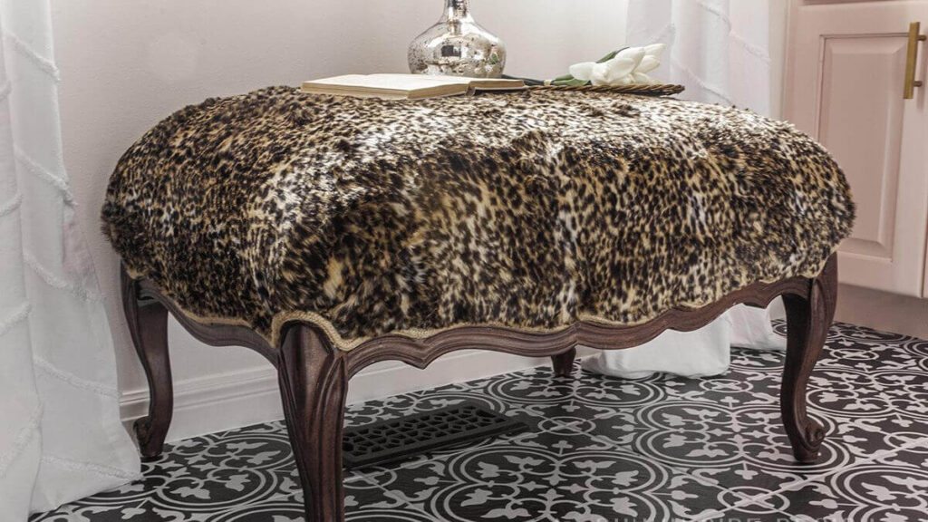 Ottoman reupholsered in a fun cheetah print faux fur with a burlap trim.