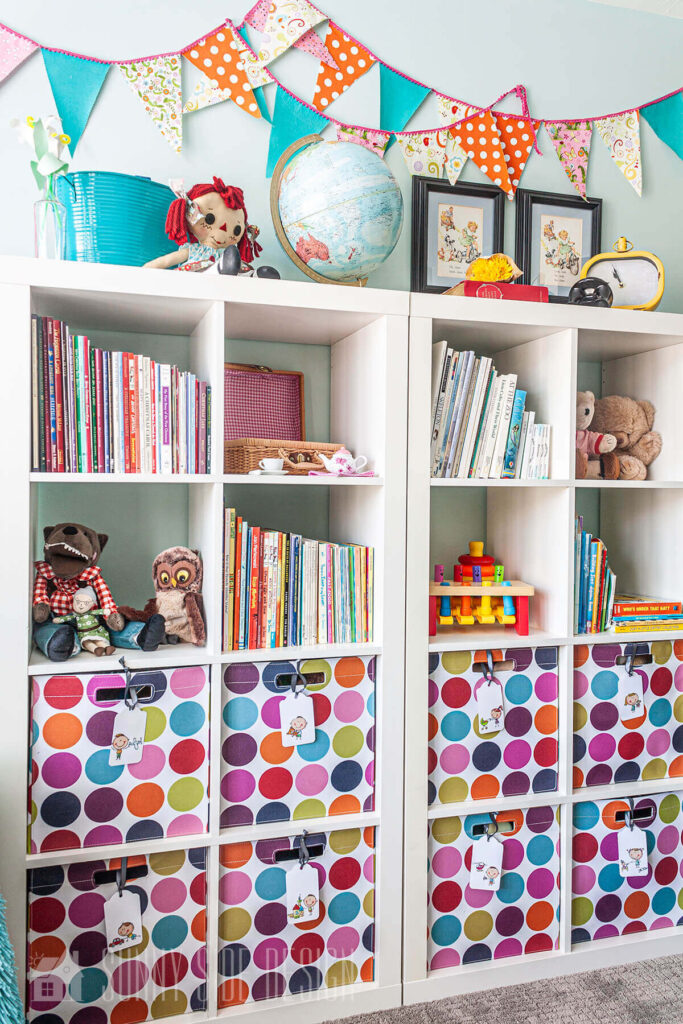 Colorful toy room with books and toys organized in labeled bins.