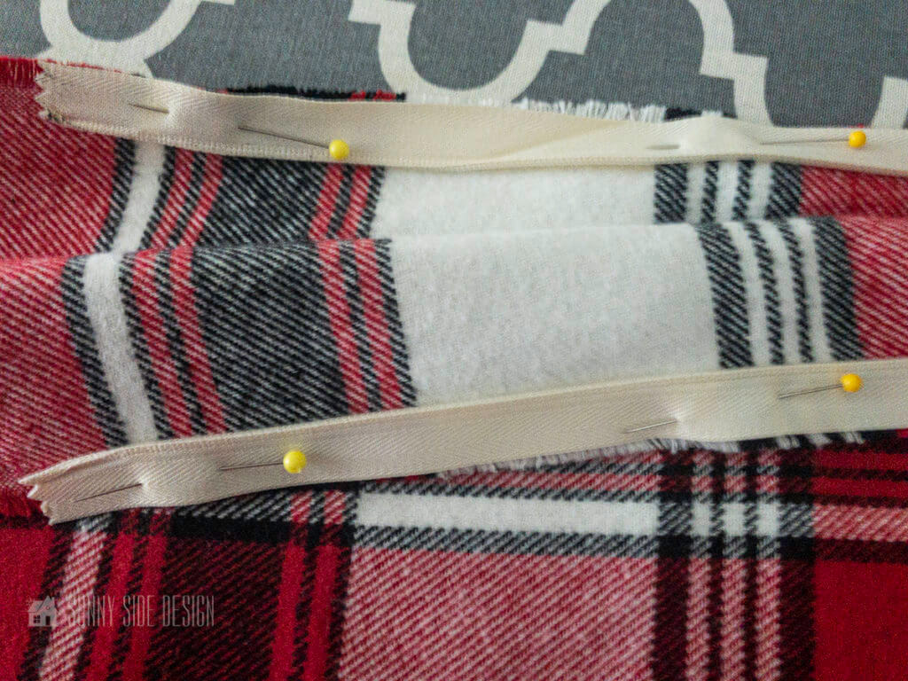 Invisible zipper is pinned onto the red plaid fabric.