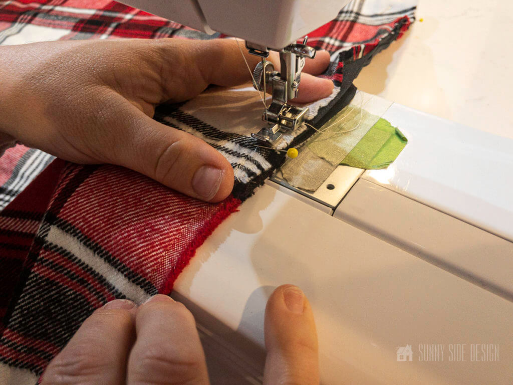 Stitching red plaid fabric for an easy pillow cover for Christmas.