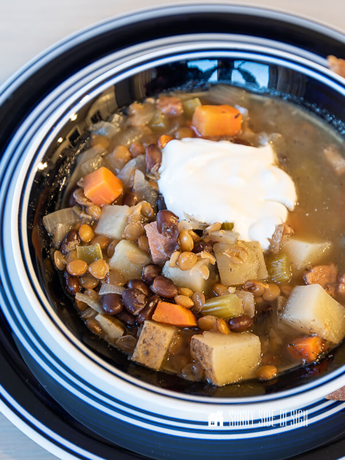 Bean and lentil soup with carrots and potatoes and a dollop of sour cream.