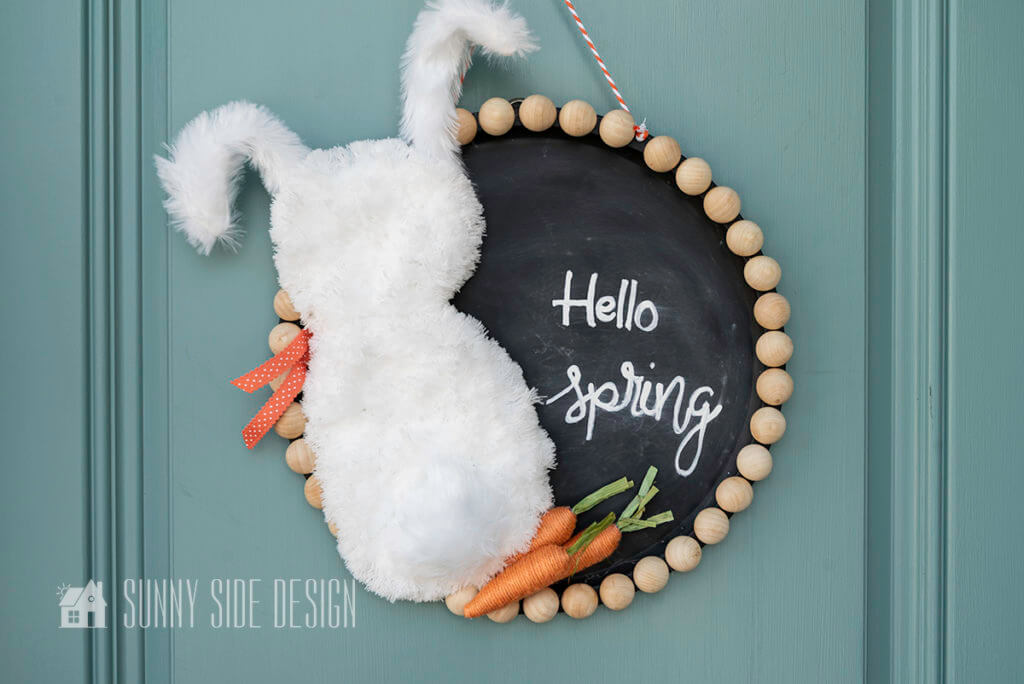Dollar Tree is always a great place to find craft supplies, and this Easter wreath is the perfect proof. This wreath uses a fluffy micro fiber dust mop as the body of the bunny, making it super easy and cheap to recreate. Plus the beads give it a Modern Boho vibe. Follow our simple tutorial to make your own! #wreathforspring #Easterwreath #easterwreathDIY