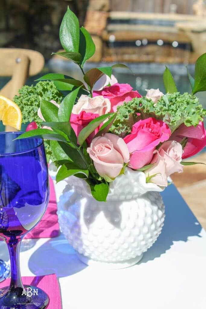 Easter table centerpiece of fresh flowers in a hobnail vase.