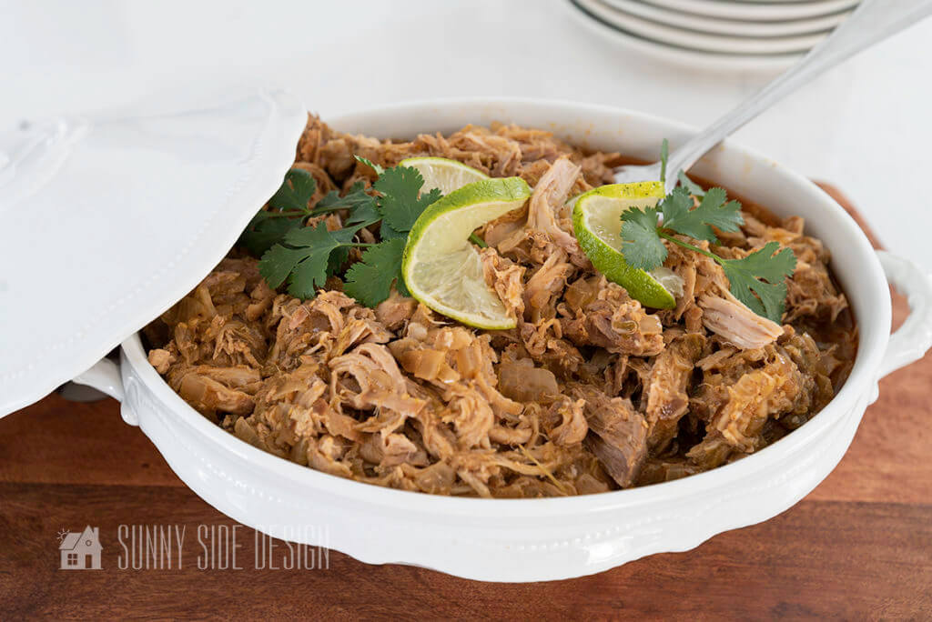 Crockpot Pork Loin Recipe, shredded and garnished with cilantro and limes.