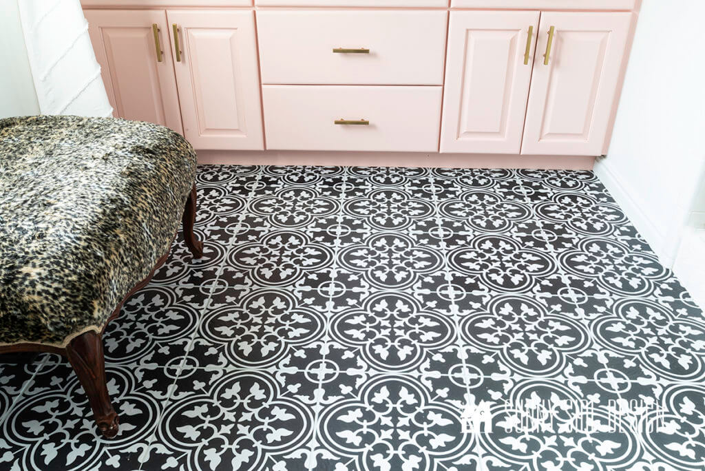 Black and White Self Adhesive Floor Tiles in a master bathroom with a light pink vanity with gold hardware and a faux fur ottoman