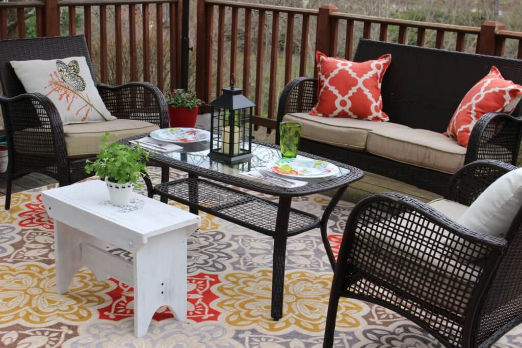 Create an inviting outdoor living space with wicker furniture and colorful pillows.
