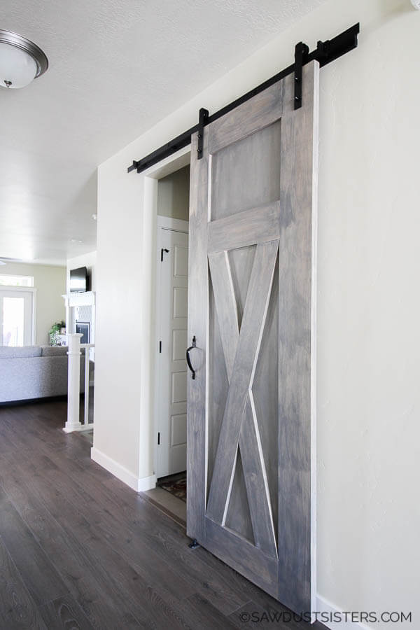 Modern Sliding Barn Door stained grey, mounted against a white wall with black sliding barn door hardware.