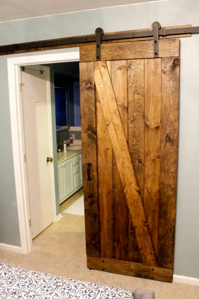 Rustic DIY sliding barn door for a bathroom.
