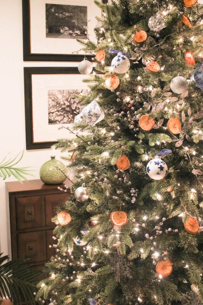 Christmas decorating trends for the Christmas tree decorations made from dried oranges and blue and white ornament balls.