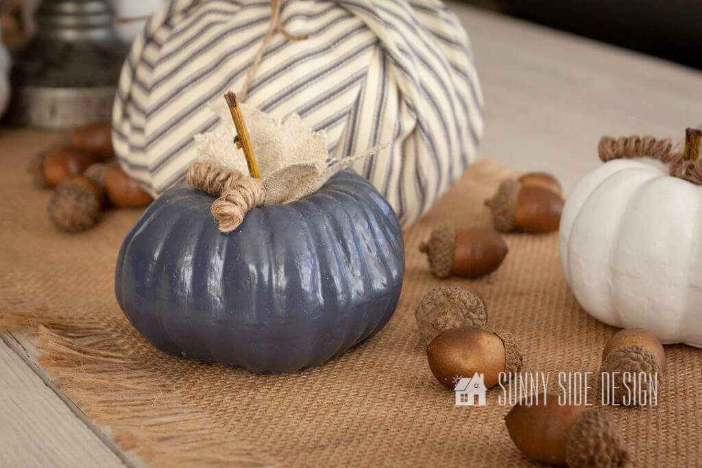 Cozy Fall Decor for your Home. Burlap table runner on a table with pumpkins and acorns.