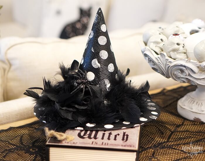 Easy black and white decoupage witch hat with black feathers on coffee table.