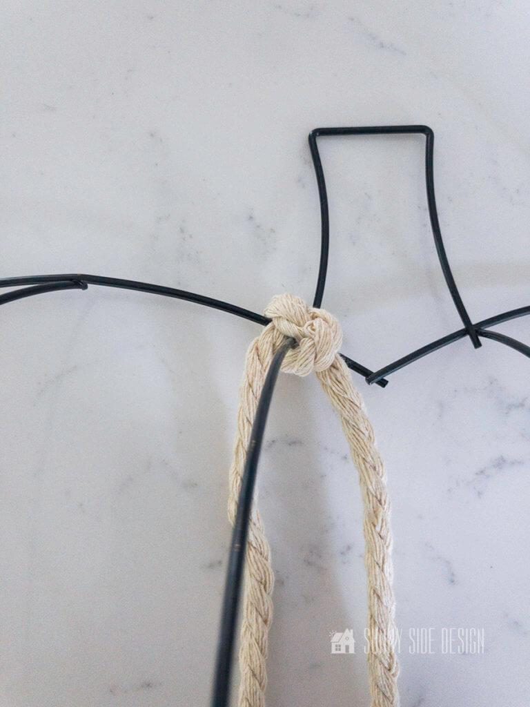 Macrame cord knotted to the top of the wire pumpkin frame.