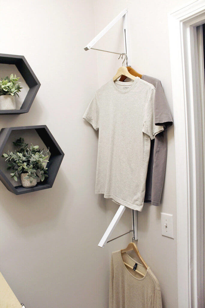 Dryin rack mounted to laundry room wall wth octagonal wall shelved and plants.