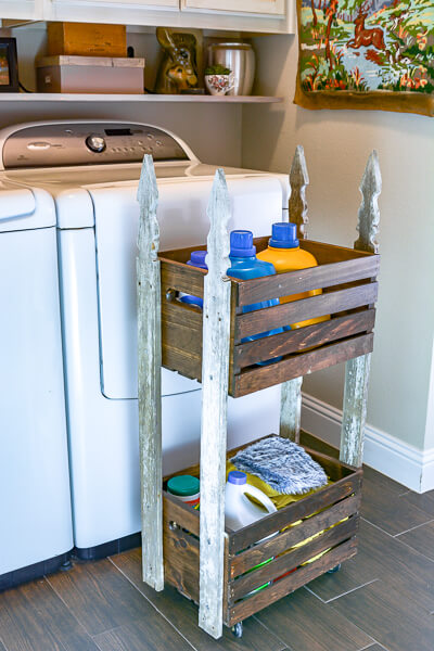 Pull out DIY laundry cart made with crates and vintage fence pickets.