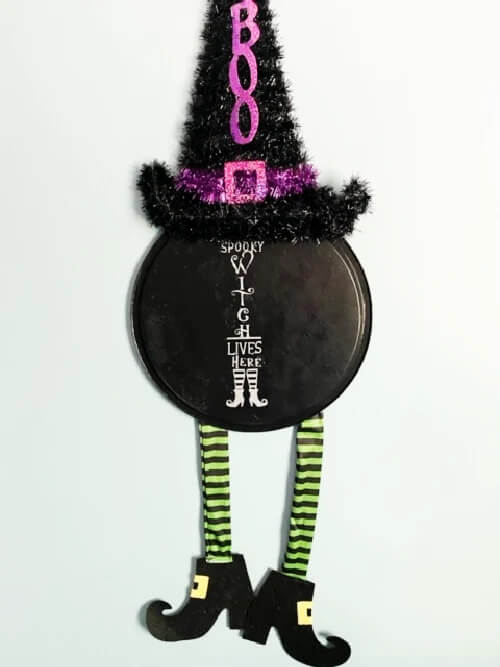 Fun Dollar Tree Witch wreath using a pizza pan, and, hat and lets.