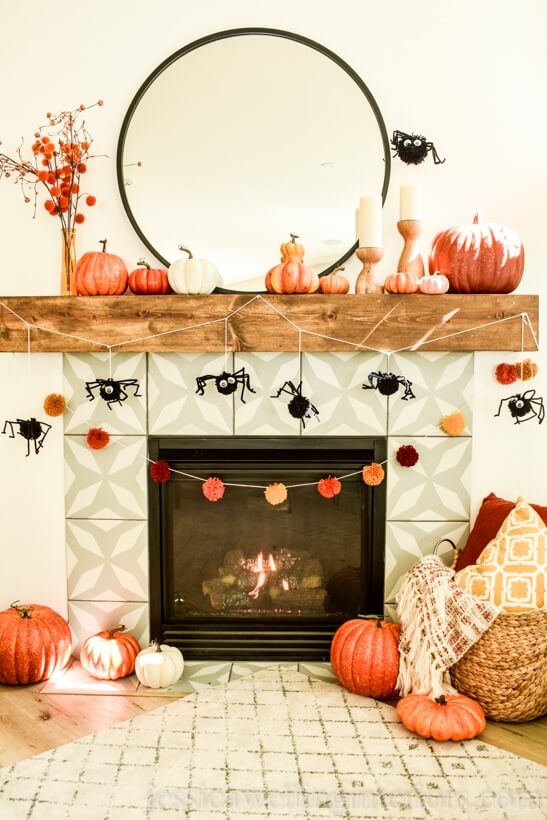 DIY spider pom pom garland hung on mantle, easy DIY Halloween Decorations.