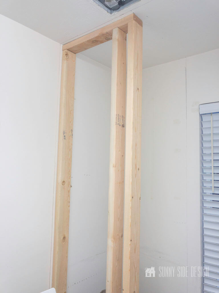 Lumber framed for wall of small closet in a laundry room.