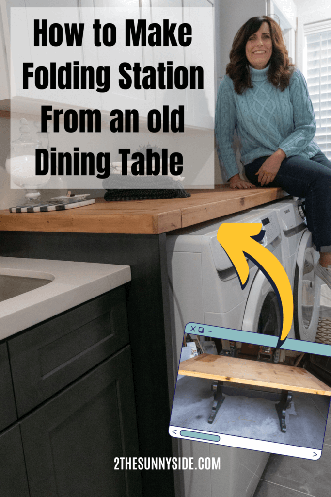 Woman with a blue sweater and jeans in laundry room sitting on newly built wood folding table. White front loading laundry appliances, white and black shaker cabinets.