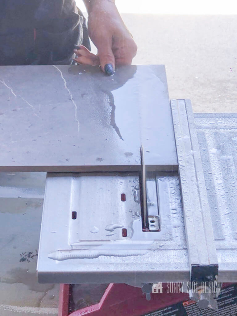 Woman trimming tile with a wet tile saw trimin