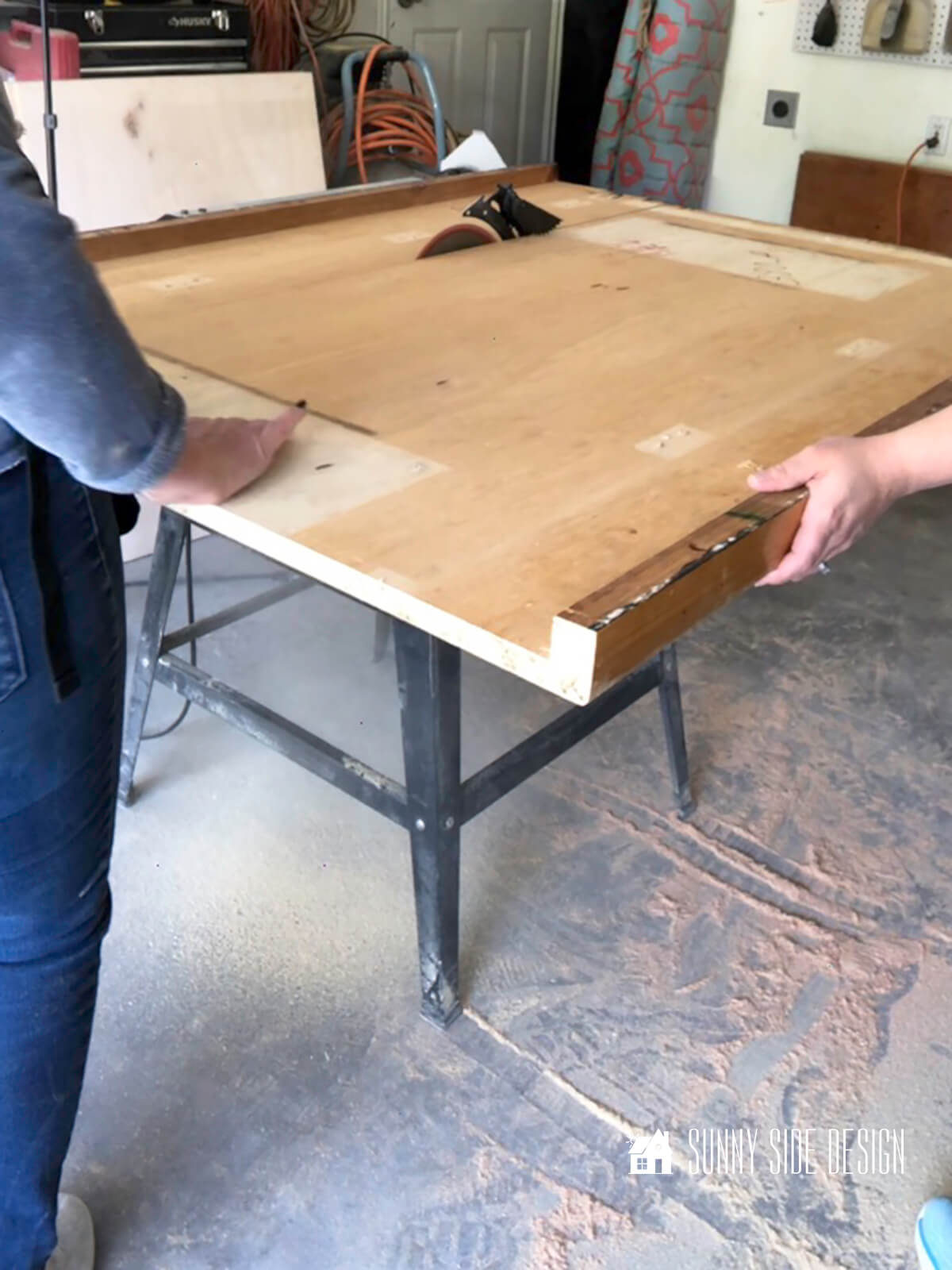 Woman standing at the table saw guiding wood laundry room folding table top.
