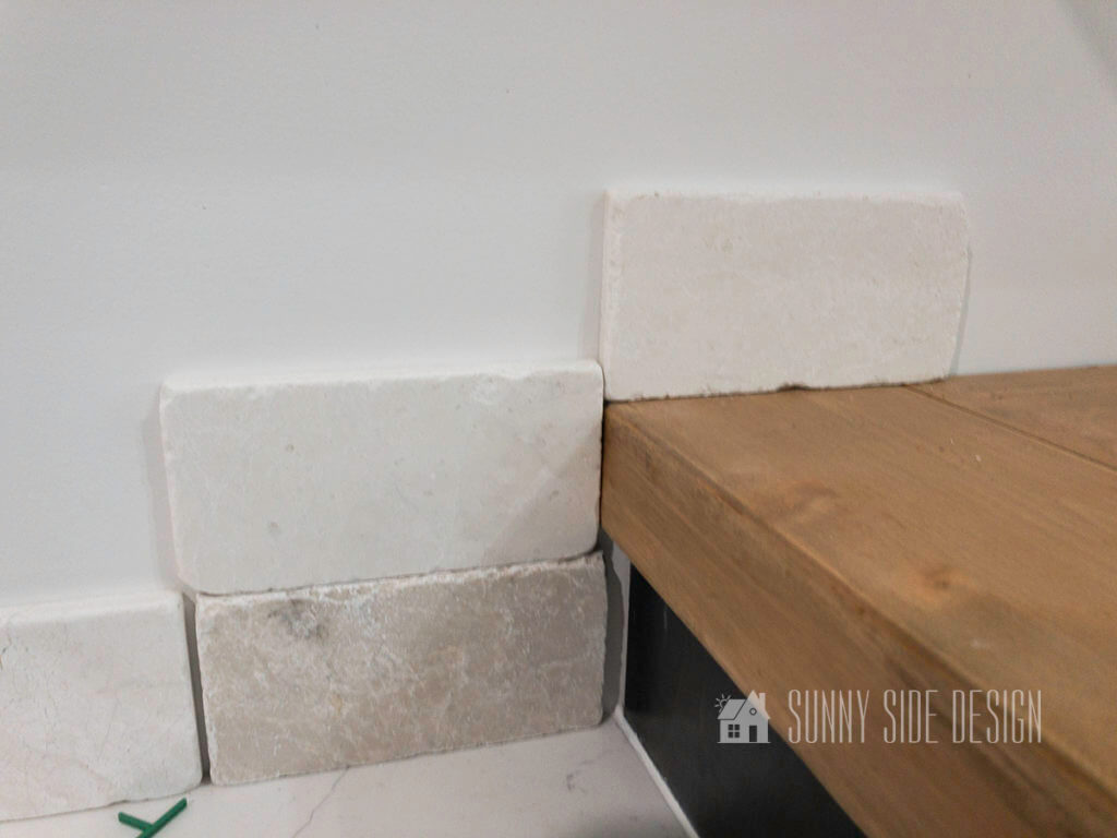 Placing tiles along wall to determine pattern and placement before install a tile backsplash.