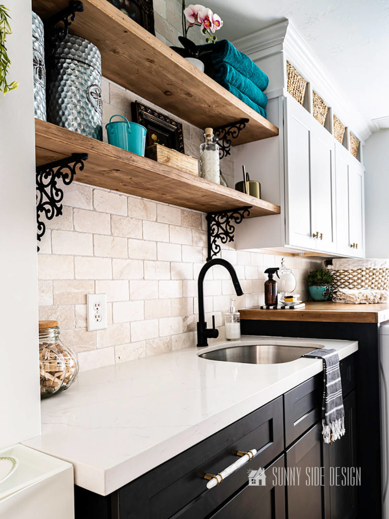 Off white marble tile backsplash with open shelving, styled with cottage feel accessories, quartz countertop, shaker cabinets and black hardware.