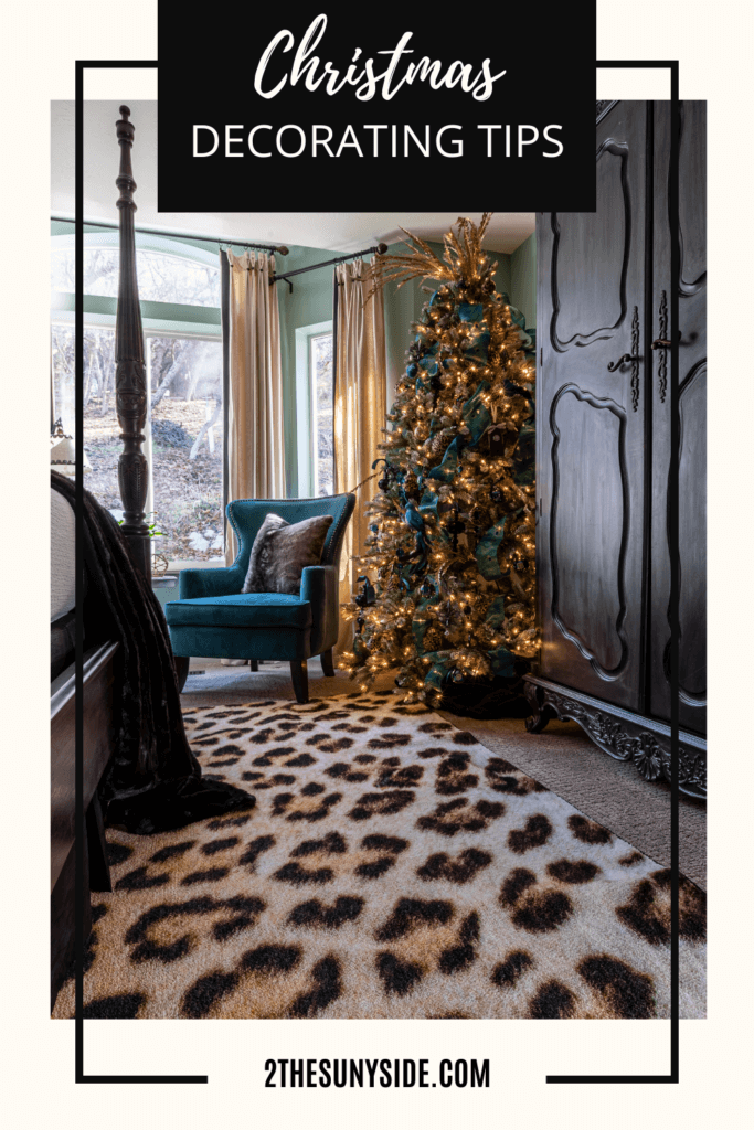Decorating bedroom for Christmas with a flocked Christmas tree decorated with gold glitter ornaments, black glitter ornaments, cheetah print ball ornaments, peacock blue ribbon and gold glitter stem picks.