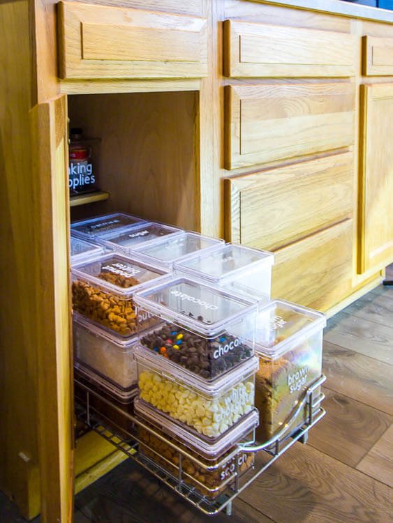 Pantry Organization Ideas - Clear rectangle containers labeled with white vinyl lettering for baking suppies, brown sugar, sugar, flour, chocolate chips, white chocolate, peanuts.