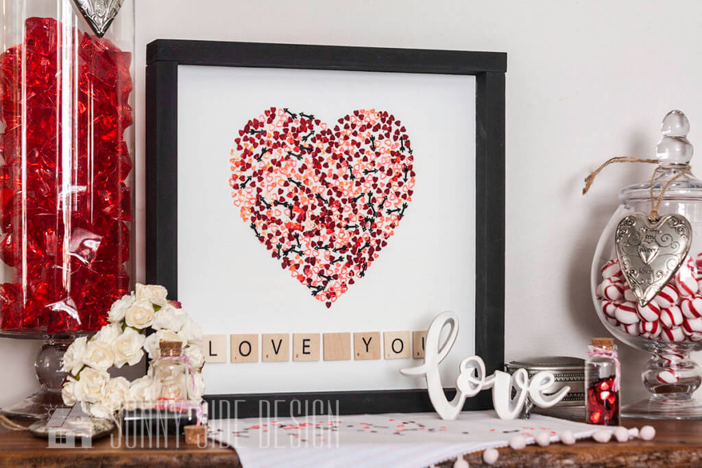 DIY Valentine's Day Decoration, valentine confetti forming a heart on a white painted board with scrabble letter tiles spelling out "Love You"