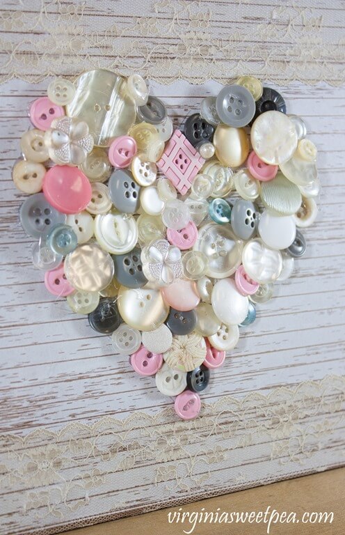 Easy DIY Valentine's Day Decoration, vintage buttons forming a heart on shiplap board.