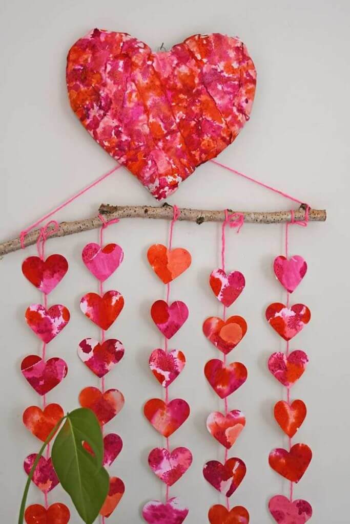 DIY Valentine's Day decorations, watercolor hearts hanging from a stick wall art.