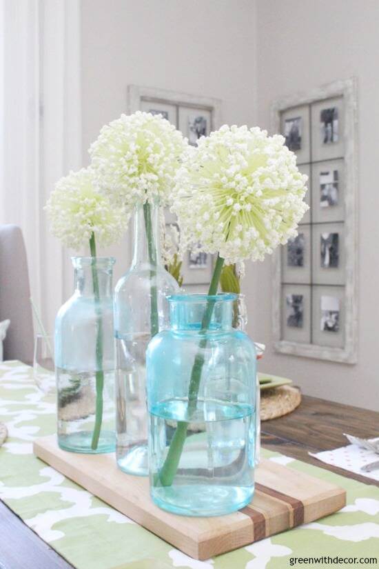 Easter Tablescape ideas, simple centerpiece with 3 glass bottles and 3 white allium stems.