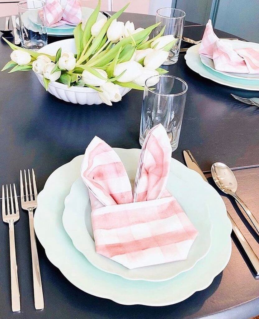 Clever bunny shape folded napkin on light blue plates., white tulip centerpiece