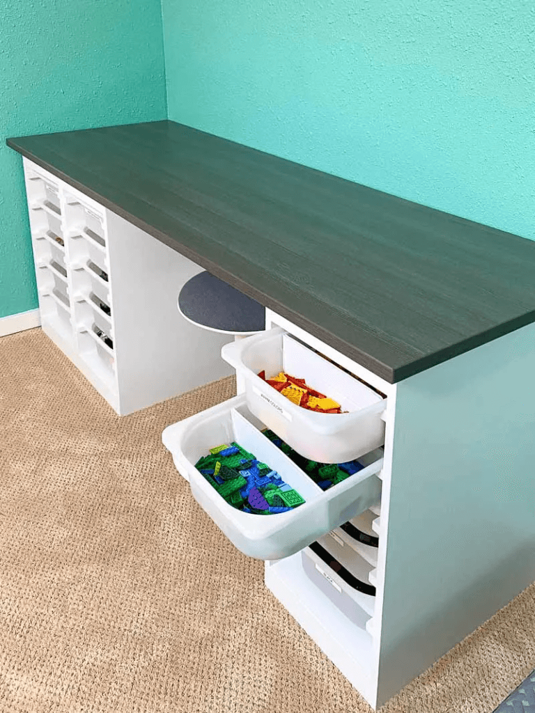 Toy organizing ideas, DIY white wood lego table wiith sliding white storage bins that hold legos sorted by color.