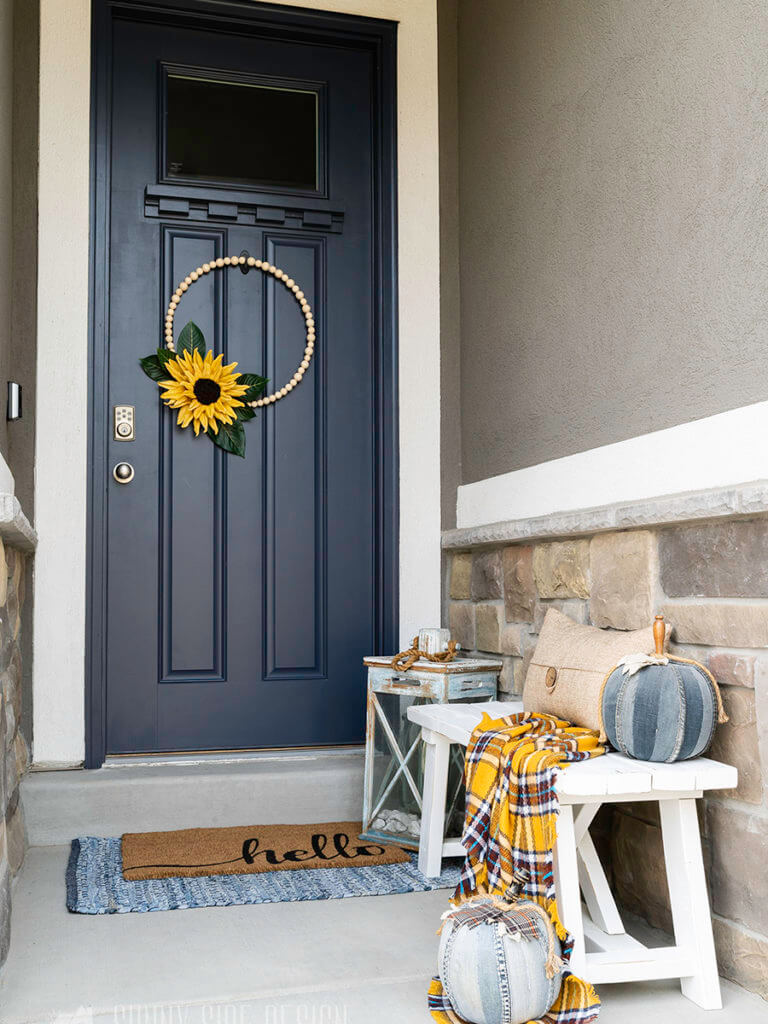 Curb appeal ideas, Navy blue front door with a modern bead wreath with a large yellow sunflower.