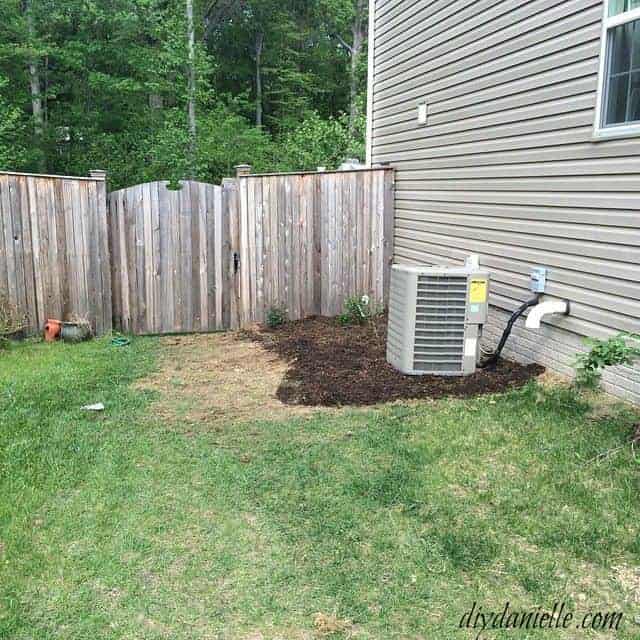 Side yard of home with areas of dead grass, and airconditioner unit.