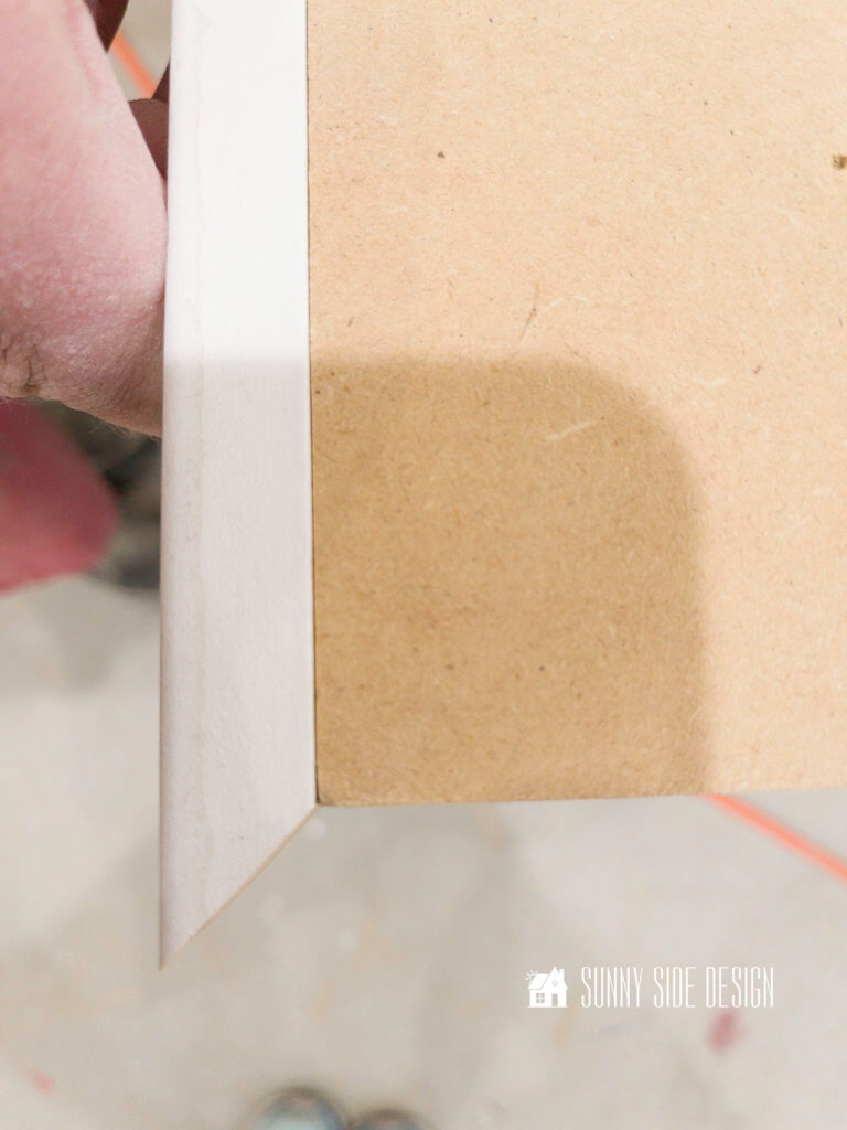White primed molding is attached to the edge of the MDF board for a DIY epoxy countertop.