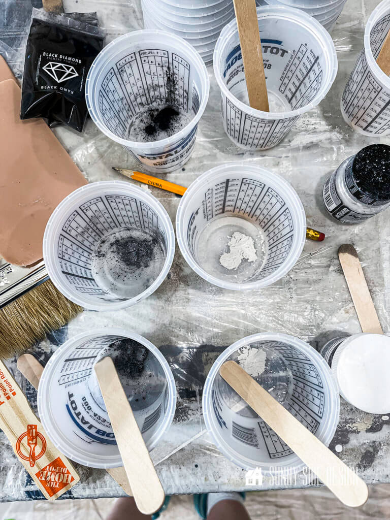 A small amount of Mica powder is placed in small buckets with wooden stirsticks.